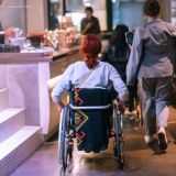 A girl in a wheelchair in a café near the bar. Accessible café for people with special needs