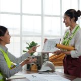 Two female architects are discussing a blueprint in a modern office, showcasing teamwork and collaboration in architectural design