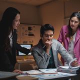 Business team supporting a stressed manager experiencing burnout in a dark office