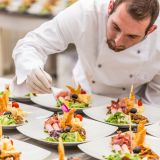 Chef is decorating delicious appetizer dish, fine dining restaurant