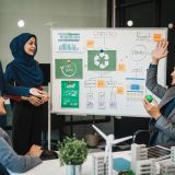 Diverse team, middle-aged Asian businessman, Caucasian young businesswoman, Muslim hijab-wearing