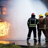 Firemen training to put out fire on burning building, Darlington, UK