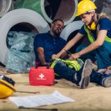 First aid support accident at work of worker at factory. Male worker has an accident on the floor in warehouse site