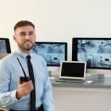 Male security guard with portable transmitter at workplace