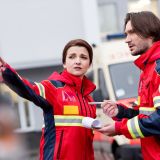 Paramedics with clipboard and pen talking on street