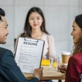 Young Asian woman graduate interviewing with two manager when discuss about her resume with serious motion in meeting room,Business Hiring new member concept