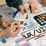 Developer and ux designer brainstorming and working on mobile app interface wireframe design together.