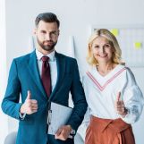 handsome recruiter and blonde woman showing thumbs up in office