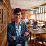 Portrait of happy female professor during a class at high school looking at camera. Copy space.