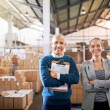 Portrait of two mangers standing in a large warehouse.