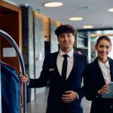 Portrait of happy hotel receptionists in a hallway looking at camera.