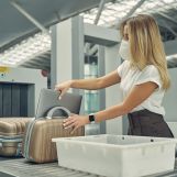 Kind blonde woman wearing protective mask while having business trip during quarantine period