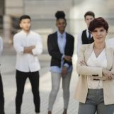 portrait of caucasian mature business woman boss in front of her coworkers